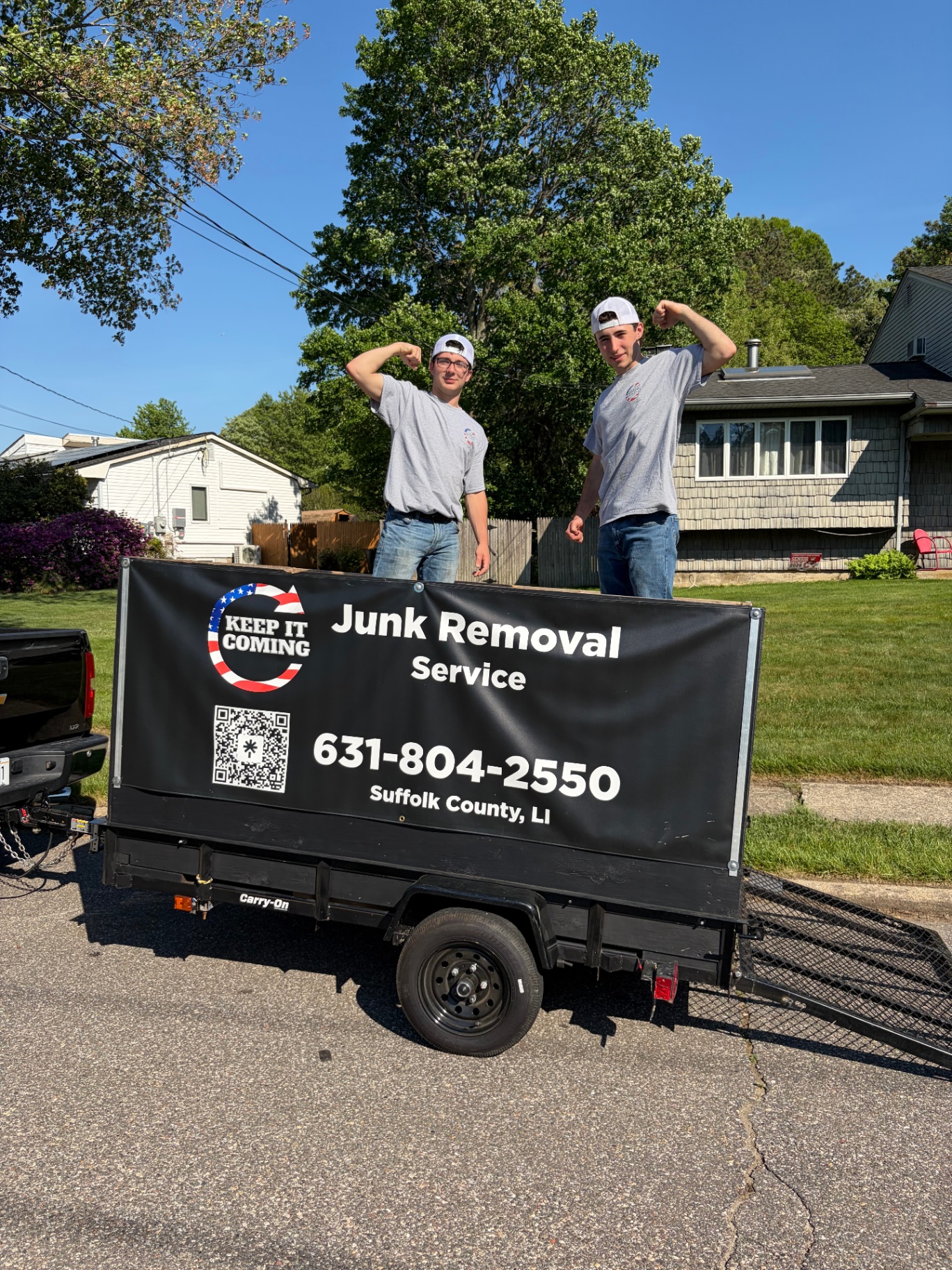 Keep It Coming Junk Removal owners with branded trailer